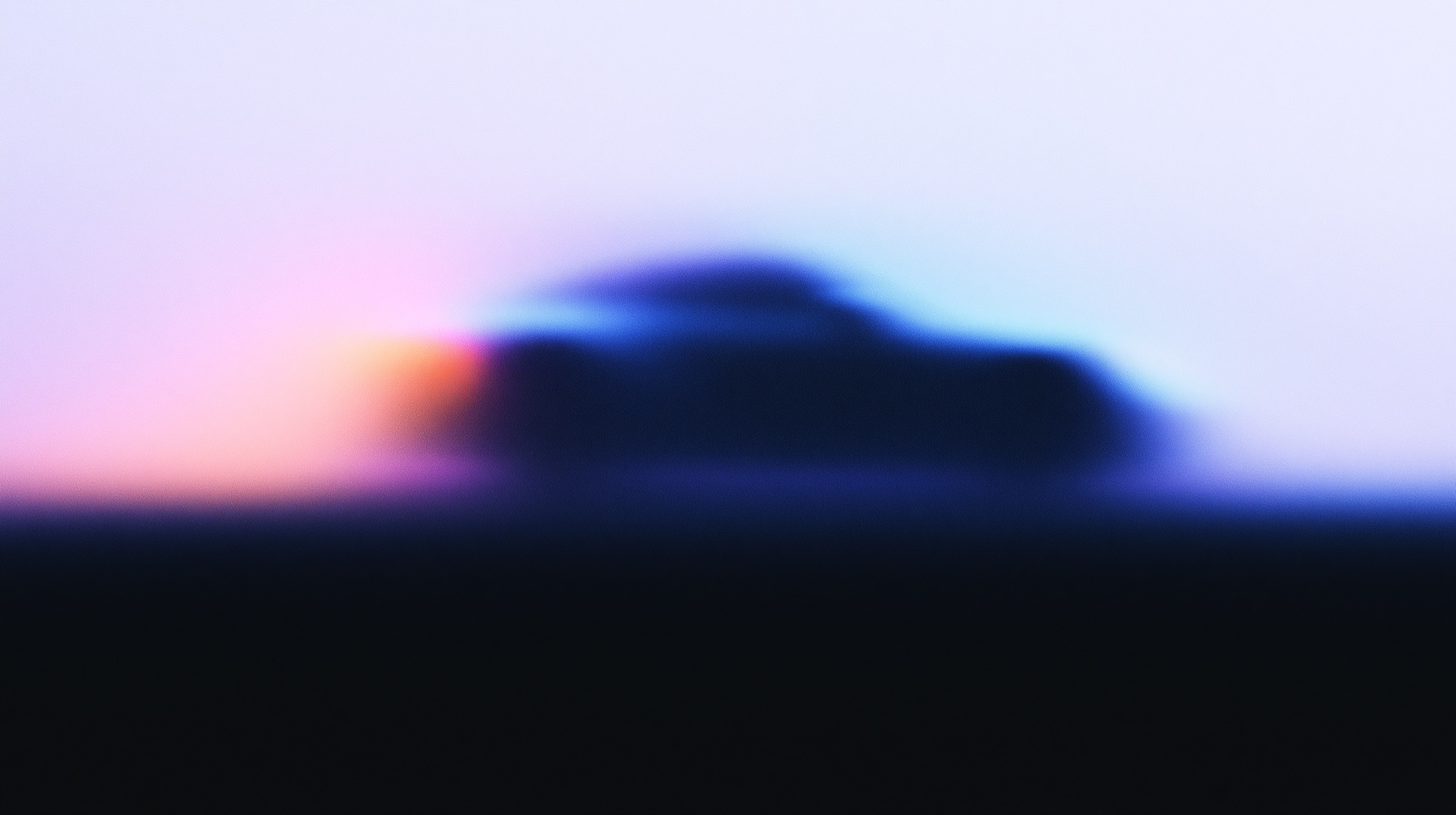 Abstract blurred silhouette of a sports car glowing in blue and coral light