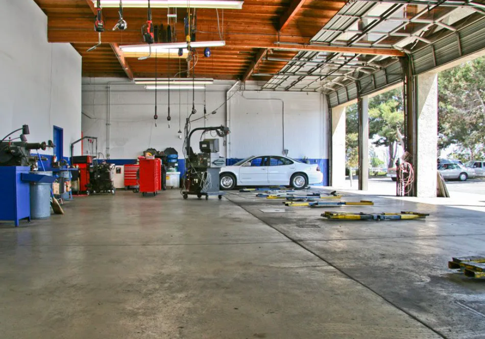 Open auto repair service bays with a vehicle and shop equipment