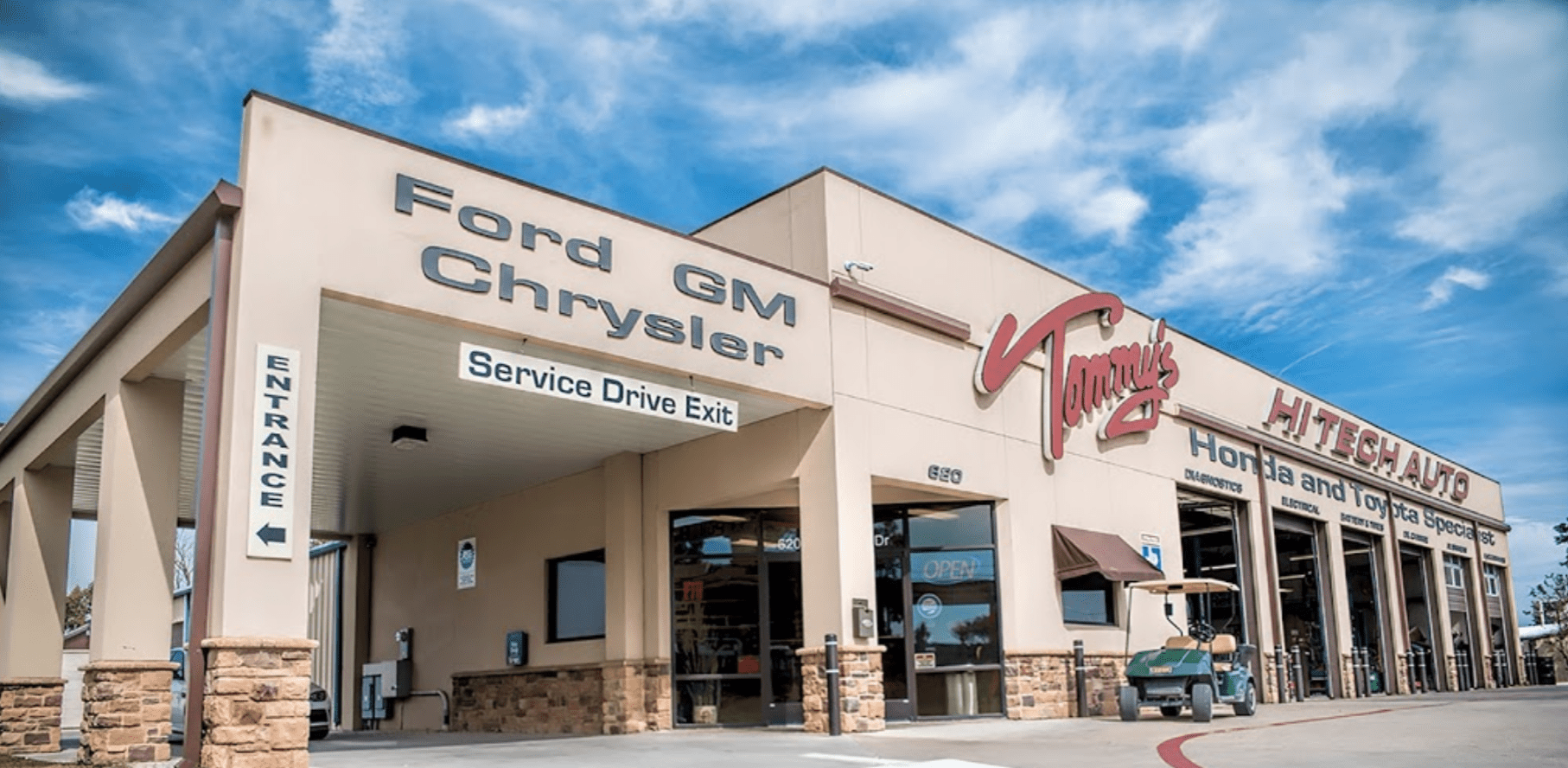 Auto repair shop exterior with open service bays and visible signage