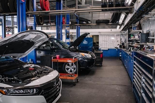 Clean auto repair service bays with vehicles ready for work