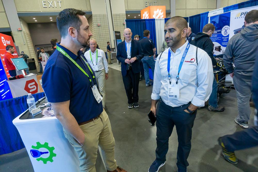 Turnkey Marketing team member speaking with shop owners at an industry event